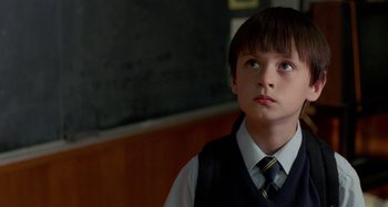 Movie still from “St. Vincent” (2014), directed by Theodore Melfi – A boy in a vest and tie looking up at a chalkboard; Close Up shot, Low angle