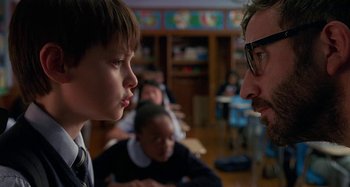 Movie still from “St. Vincent” (2014), directed by Theodore Melfi – A man and a boy in a room with other people; Close Up shot, Over the shoulder angle