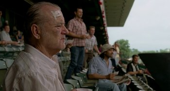 Movie still from “St. Vincent” (2014), directed by Theodore Melfi – A group of people sitting in a stadium; Medium shot, Over the shoulder angle