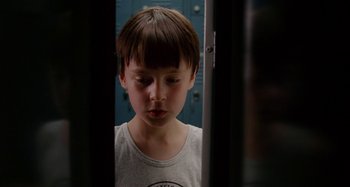 Movie still from “St. Vincent” (2014), directed by Theodore Melfi – A young boy standing in front of lockers looking sad; Close Up shot, Low angle