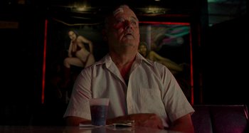 Movie still from “St. Vincent” (2014), directed by Theodore Melfi – An older man sitting at a table with a cup of coffee; Medium shot, Low angle