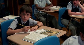 Movie still from “St. Vincent” (2014), directed by Theodore Melfi – A young boy sitting at a table in a classroom; Medium shot, High angle