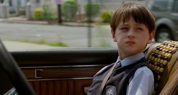 Movie still from “St. Vincent” (2014), directed by Theodore Melfi – A boy sitting in the back seat of a car; Close Up shot, Over the shoulder angle