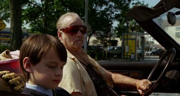 Movie still from “St. Vincent” (2014), directed by Theodore Melfi – An older man and a young boy sitting in the back of a car; Close Up shot, Low angle