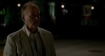 Movie still from “St. Vincent” (2014), directed by Theodore Melfi – An older man wearing a suit and tie standing outside; Close Up shot, Over the shoulder angle