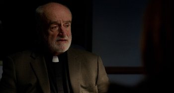 Movie still from “St. Vincent” (2014), directed by Theodore Melfi – An older man wearing a suit and a priest's collar; Close Up shot, Over the shoulder angle
