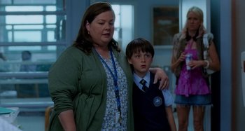 Movie still from “St. Vincent” (2014), directed by Theodore Melfi – A woman standing next to a young boy in a room; Medium shot, Over the shoulder angle