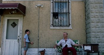 Movie still from “St. Vincent” (2014), directed by Theodore Melfi – An older man sitting on a lawn chair next to a young boy; Wide shot, Low angle