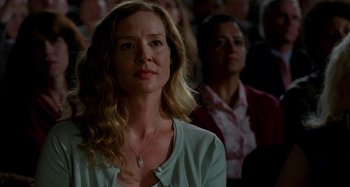 Movie still from “St. Vincent” (2014), directed by Theodore Melfi – A woman is standing in front of a group of people; Close Up shot, Over the shoulder angle