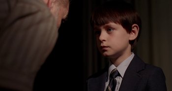 Movie still from “St. Vincent” (2014), directed by Theodore Melfi – A boy in a suit and tie looking at an older man; Close Up shot, Over the shoulder angle