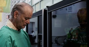 Movie still from “St. Vincent” (2014), directed by Theodore Melfi – An older man wearing a green shirt looking at a window; Close Up shot, Low angle