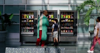 Movie still from “St. Vincent” (2014), directed by Theodore Melfi – A man and a boy standing in front of vending machines; Wide shot, Over the shoulder angle