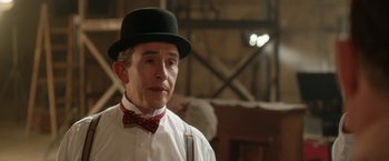 Movie still from “Stan & Ollie” (2018), directed by Jon S. Baird – A man wearing a hat and a bow tie; Close Up shot, Over the shoulder angle