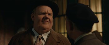 Movie still from “Stan & Ollie” (2018), directed by Jon S. Baird – A man in a suit and a hat talking to another man in a suit; Close Up shot, Over the shoulder angle