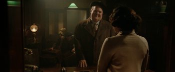 Movie still from “Stan & Ollie” (2018), directed by Jon S. Baird – A man standing at a table with a woman; Medium shot, Over the shoulder angle