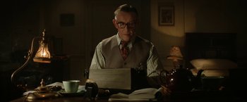 Movie still from “Stan & Ollie” (2018), directed by Jon S. Baird – An older man sitting at a table with a laptop; Medium shot, Low angle