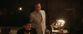 Movie still from “Stan & Ollie” (2018), directed by Jon S. Baird – A man standing next to another man and a woman; Medium shot, Low angle