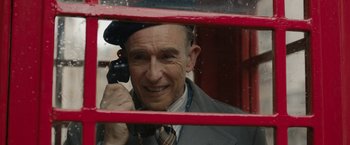 Movie still from “Stan & Ollie” (2018), directed by Jon S. Baird – An older man talking on a cell phone through a window; Close Up shot, Low angle