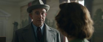 Movie still from “Stan & Ollie” (2018), directed by Jon S. Baird – An older man wearing a suit and a hat looking at a cat; Close Up shot, Over the shoulder angle