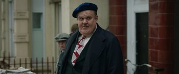 Movie still from “Stan & Ollie” (2018), directed by Jon S. Baird – A man in a blue hat and a red tie; Medium shot, Low angle