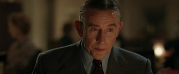 Movie still from “Stan & Ollie” (2018), directed by Jon S. Baird – An older man wearing a suit and tie; Close Up shot, Over the shoulder angle