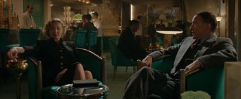 Movie still from “Stan & Ollie” (2018), directed by Jon S. Baird – People are sitting in a restaurant with green chairs; Medium shot, Over the shoulder angle