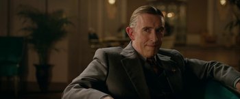 Movie still from “Stan & Ollie” (2018), directed by Jon S. Baird – A man in a suit and tie sitting in a chair; Close Up shot, Over the shoulder angle