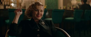 Movie still from “Stan & Ollie” (2018), directed by Jon S. Baird – A woman sitting in a chair smiling for the camera; Close Up shot, Over the shoulder angle