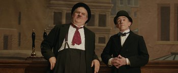 Movie still from “Stan & Ollie” (2018), directed by Jon S. Baird – A couple of men standing next to each other in suits; Medium shot, Low angle