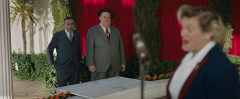 Movie still from “Stan & Ollie” (2018), directed by Jon S. Baird – A man in a suit and hat standing in front of a table; Wide shot, Over the shoulder angle
