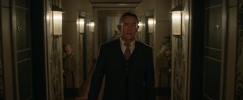 Movie still from “Stan & Ollie” (2018), directed by Jon S. Baird – A man in a suit and tie walking down a hall way; Medium shot, Low angle