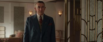 Movie still from “Stan & Ollie” (2018), directed by Jon S. Baird – A man in a suit and tie standing in front of a mirror; Medium shot, Low angle