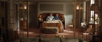 Movie still from “Stan & Ollie” (2018), directed by Jon S. Baird – Two men sitting on a bed in a room; Wide shot, High angle