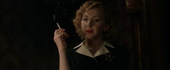 Movie still from “Stan & Ollie” (2018), directed by Jon S. Baird – A woman holding a cigarette in her right hand; Close Up shot, Low angle