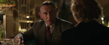 Movie still from “Stan & Ollie” (2018), directed by Jon S. Baird – An older man wearing a suit and tie talking to a woman; Close Up shot, Over the shoulder angle