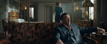 Movie still from “Stan & Ollie” (2018), directed by Jon S. Baird – An older man sitting on a couch in front of a woman; Medium shot, Over the shoulder angle