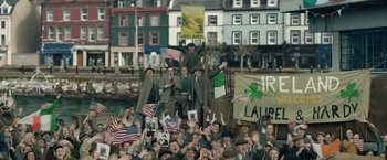 Movie still from “Stan & Ollie” (2018), directed by Jon S. Baird – A group of men in suits and hats are standing on a boat; Wide shot, High angle