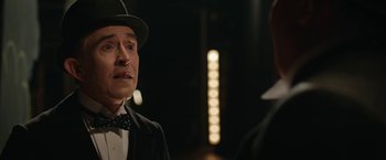 Movie still from “Stan & Ollie” (2018), directed by Jon S. Baird – A man wearing a hat and a bow tie standing in front of another man; Close Up shot, Over the shoulder angle