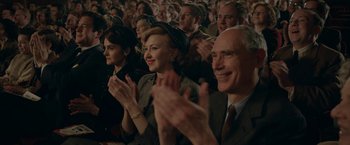Movie still from “Stan & Ollie” (2018), directed by Jon S. Baird – A group of people sitting and clapping in a crowd; Medium shot, Over the shoulder angle