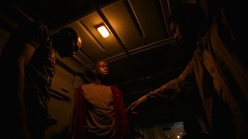 Movie still from “Full Circle” (2023), directed by Steven Soderbergh – Two men are standing in a room and one of them is holding his hand out to another man; Medium shot, Low angle