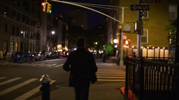 Movie still from “Full Circle” (2023), directed by Steven Soderbergh – A man walking down a street at night; Wide shot, Over the shoulder angle