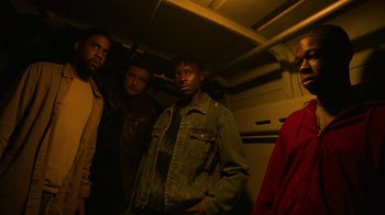Movie still from “Full Circle” (2023), directed by Steven Soderbergh – A group of men standing next to each other in a room; Medium shot, Low angle