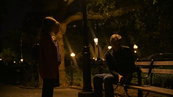 Movie still from “Full Circle” (2023), directed by Steven Soderbergh – A man and a woman sitting on a bench at night; Wide shot, Over the shoulder angle