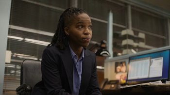 Movie still from “Full Circle” (2023), directed by Steven Soderbergh – A woman sitting in front of computer monitors; Close Up shot, Low angle