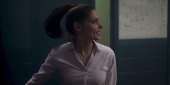 Movie still from “One Shot” (2021), directed by James Nunn – A woman in a white shirt is smiling; Close Up shot, Over the shoulder angle