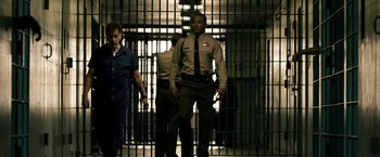 Movie still from “Stand Up Guys” (2012), directed by Fisher Stevens – A man in a jail cell with two other men behind bars; Wide shot, Low angle