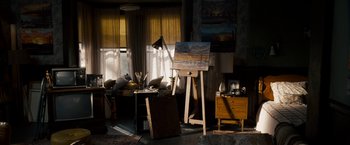 Movie still from “Stand Up Guys” (2012), directed by Fisher Stevens – An easel in the middle of a living room; Wide shot, High angle