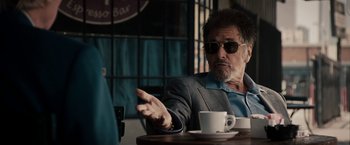 Movie still from “Stand Up Guys” (2012), directed by Fisher Stevens – An older man sitting at a table with a cup of coffee in front of him; Medium shot, Over the shoulder angle