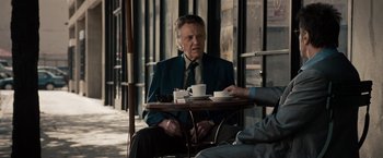 Movie still from “Stand Up Guys” (2012), directed by Fisher Stevens – An older man sitting at a table with a cup of coffee; Medium shot, Over the shoulder angle