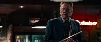 Movie still from “Stand Up Guys” (2012), directed by Fisher Stevens – An older man in a suit and tie holding a stick; Close Up shot, Low angle